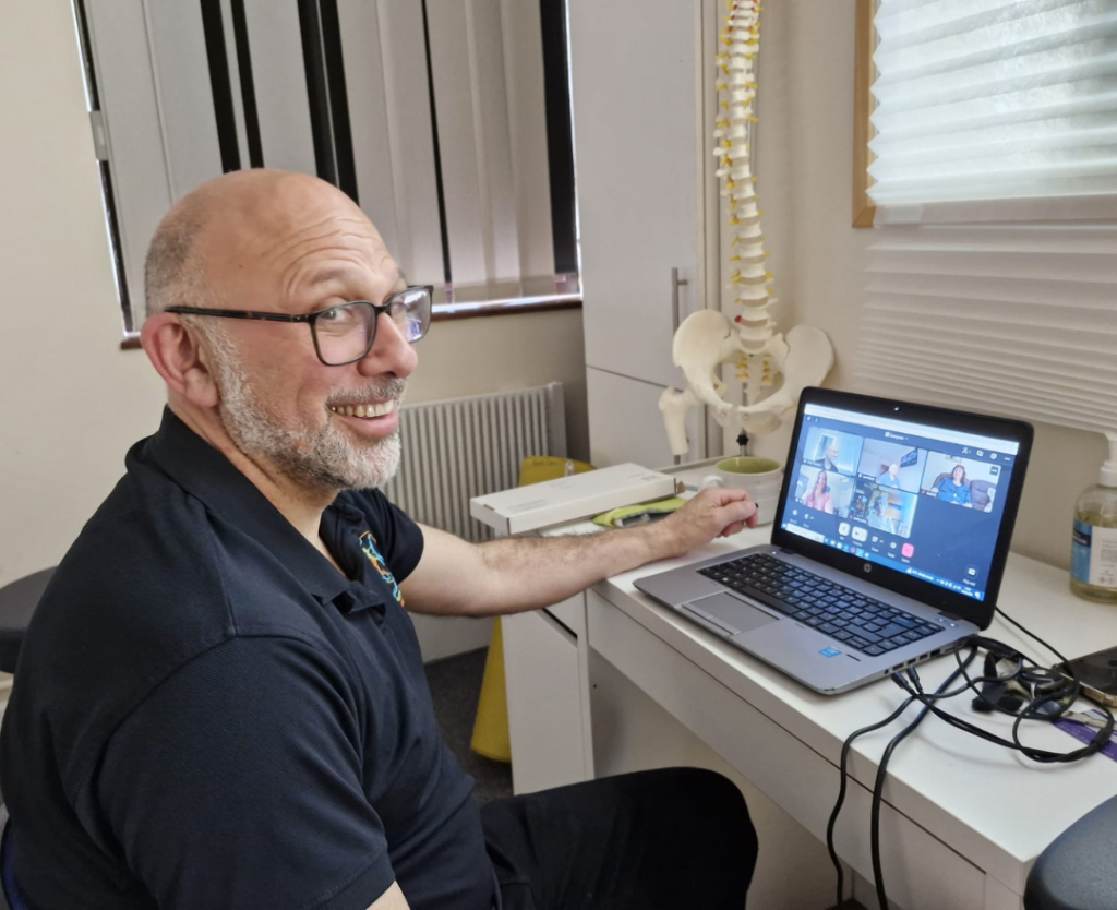France giving an online breathing and mindfulness session at his laptop in our private clinic room.