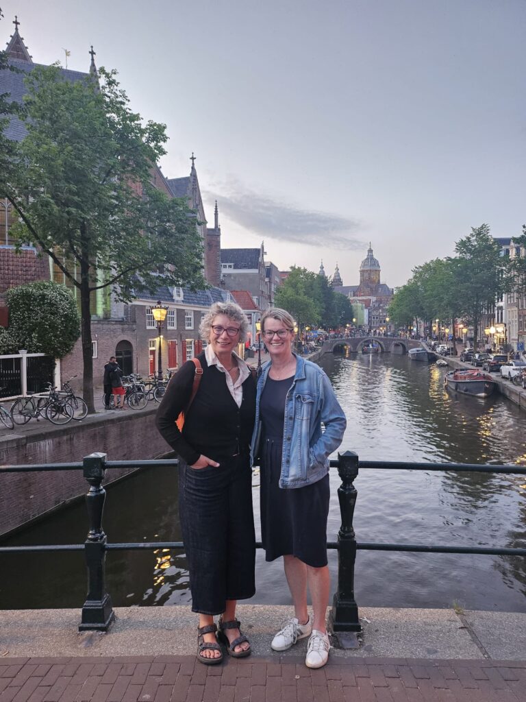Ulrike and Lynn standing on a bridge over a canal in Amsterdam. 
