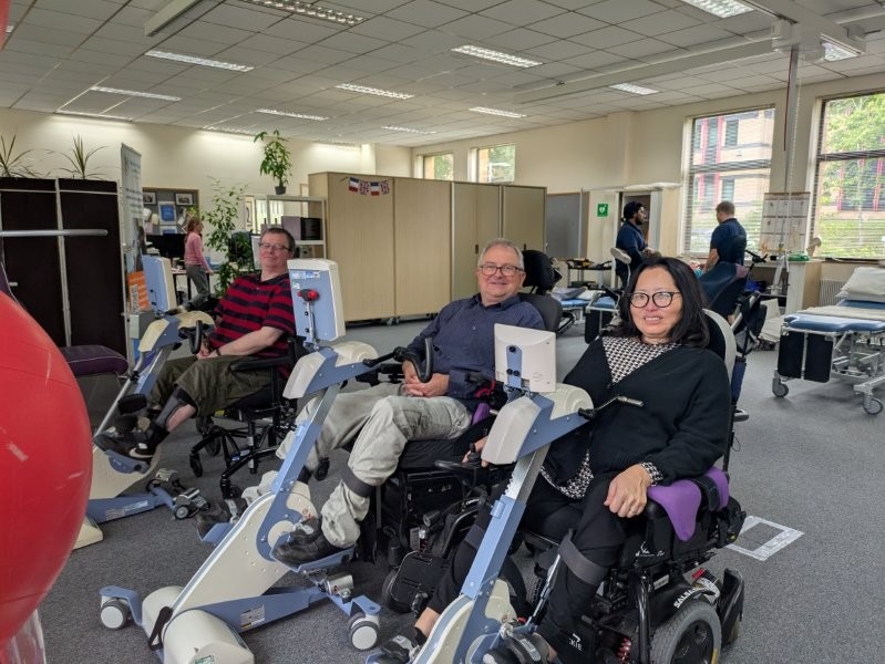 Three people using wheelchair accessible theratrainer bikes