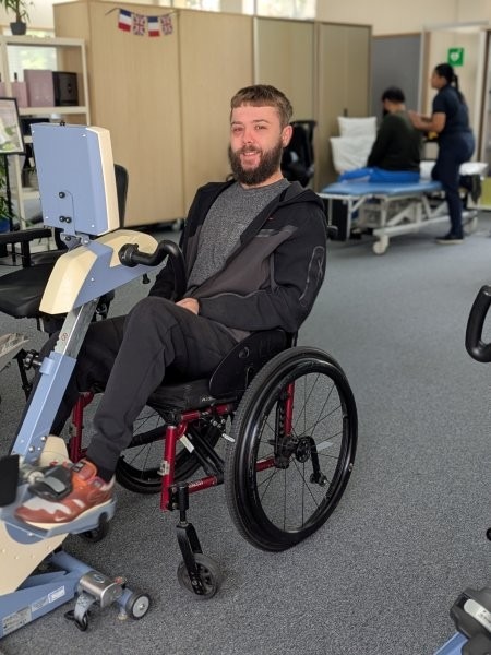 A young man in a wheelchair using an accessible bike