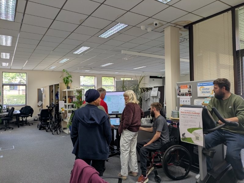 A group of people standing in from of a TV screen