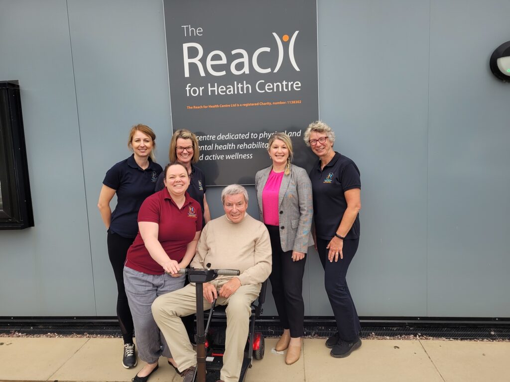 A group of people in front of Reach for Health Centre