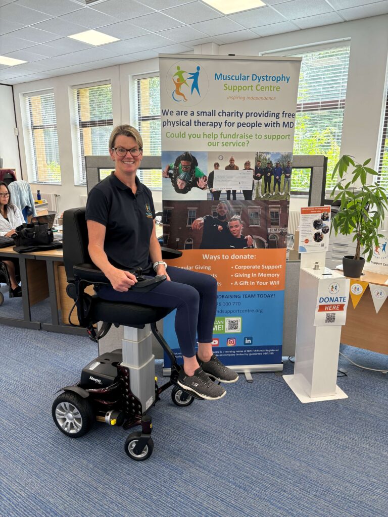 Physiotherapist Lynn demonstrates the Reno Riser powerchair in our Coventry Centre. She is sitting on the chair with the seat in the high position.