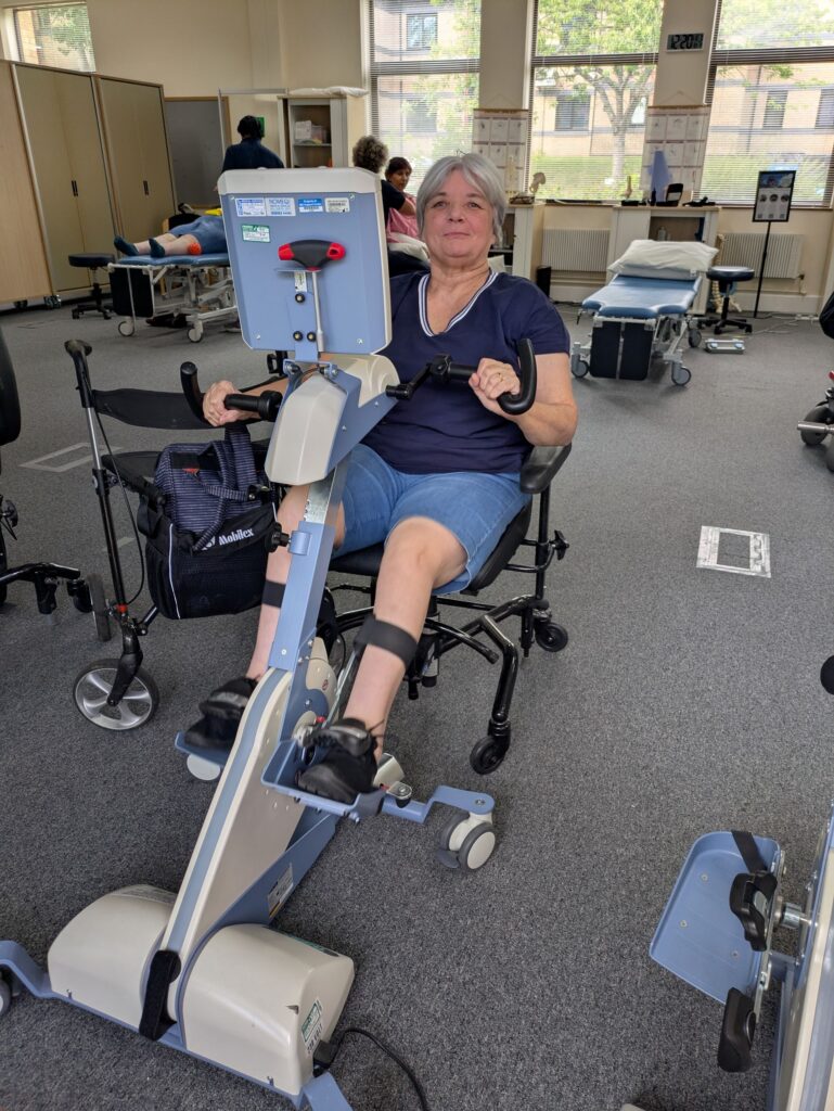 A female service user exercising on an accessible Theratrainer bike.
