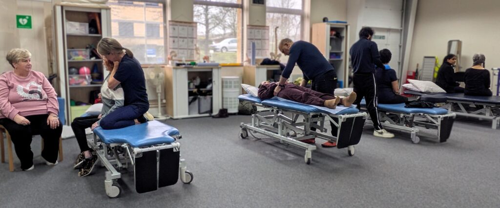 People receiving physiotherapy in our clinic. There are four people receiving treatment on therapy beds.