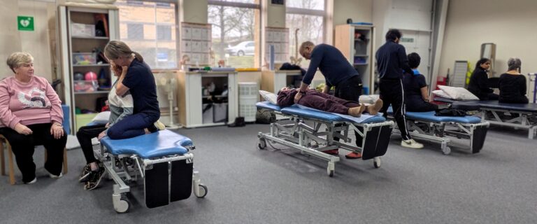 People receiving physiotherapy in our clinic. There are four people receiving treatment on therapy beds.