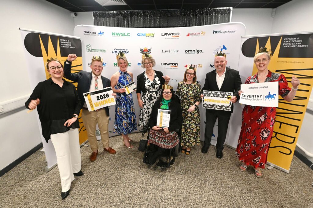 Group of award winners standing in front of Coventry & Warwickshire Business and Community Awards banners, holding certificates and “2026 Winner” signs, with sponsor logos visible behind them.