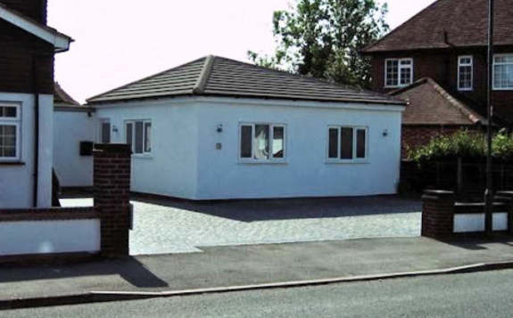 Brick building entrance to MD Support Centre Coventry with yellow-framed glass doors, signage displaying unit numbers 9 and 10, and a banner beside the doorway.