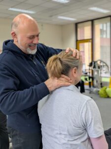 An osteopath performs hands-on therapy to a client at Muscular Dystrophy Support Centre
