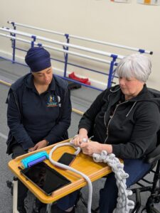 A therapist supports a service user with hand knitting during a hand therapy session