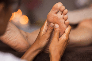 A close up shot of a therapist performing foot reflexology