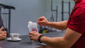 A close up of someone's hands as they prepare a protein shake