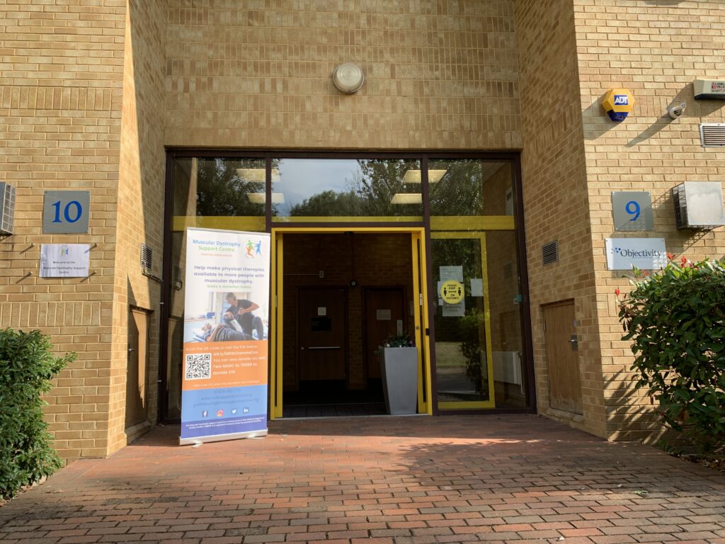 Entrance doors to Number 10 Westwood House. The automatic doors are open and there is a MD Support Centre banner,